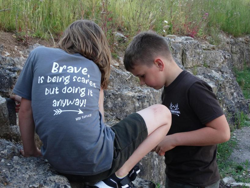 Children wearing matching shirts on a field trip in a park.