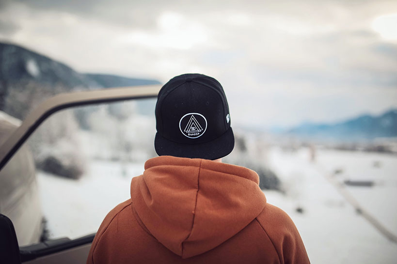 Rear view of a man wearing a custom hat backwards