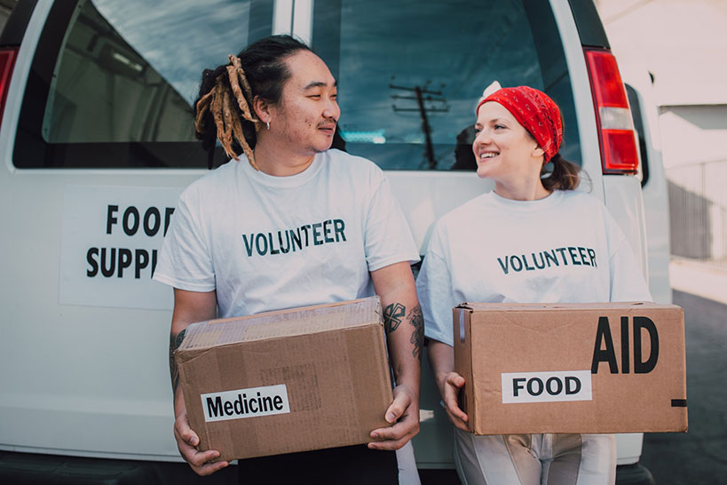 Volunteers carry boxes of food and medicine